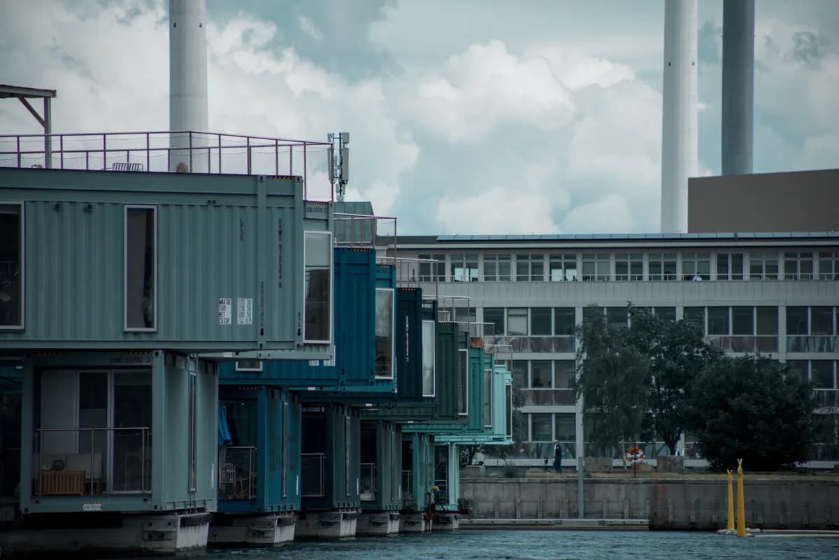 BookNoFees Beispielbild: Bunte Containerwohnbauten mit einem Steg am Wasser