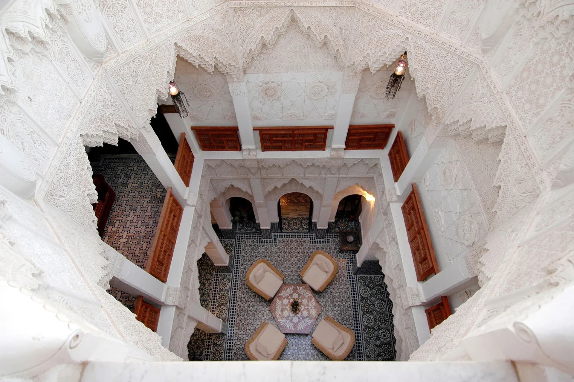 BookNoFees Beispielbild: Blick von oben in einen Riad-Innenhof mit verzierten Bögen und Sitzplätzen