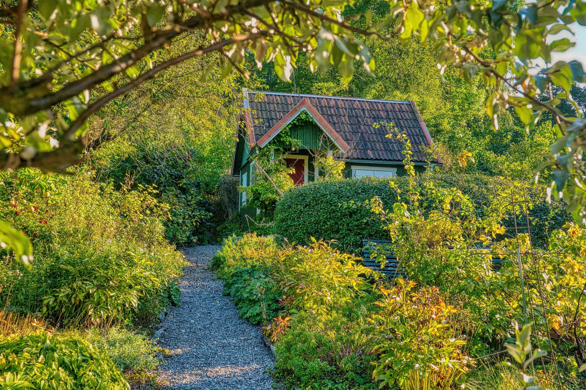 BookNoFees Beispielbild: Kleines Gästehaus hinter einem blühenden Garten