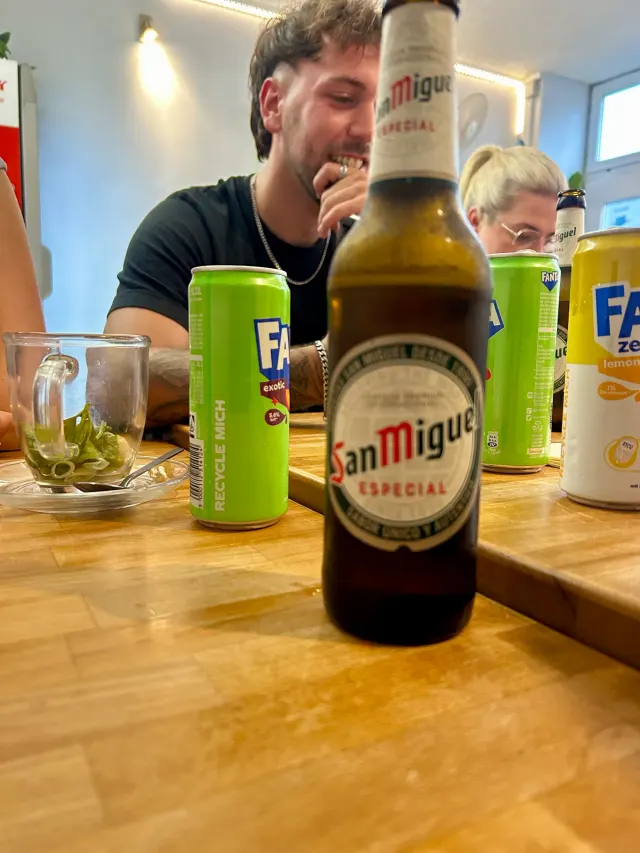 BookNoFees: Imbiss – Good morning Vietnam – Aachen – Tisch mit einer Flasche San Miguel Especial und Fanta-Dosen, Foto 2