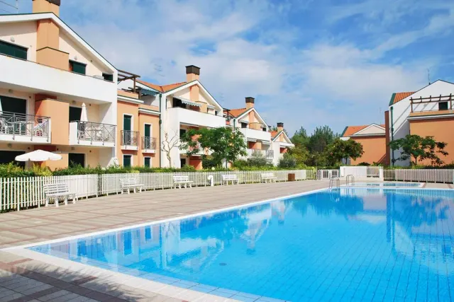 BookNoFees: Ferienwohnung in Cavallino-Treporti, Italien – ein großer Pool vor einem Gebäude von „Sunny Apartment On The Sea“ in Cavallino-Treporti