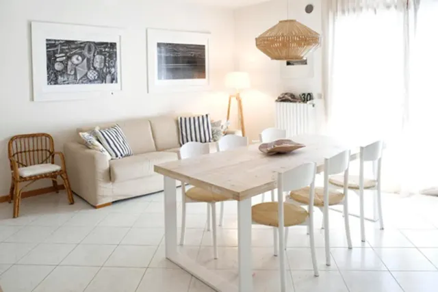 BookNoFees: Ferienwohnung in Cavallino-Treporti, Italien – Ein weißes Wohnzimmer mit Tisch und Stühlen im „Sunny Apartment On The Sea“ in Cavallino-Treporti