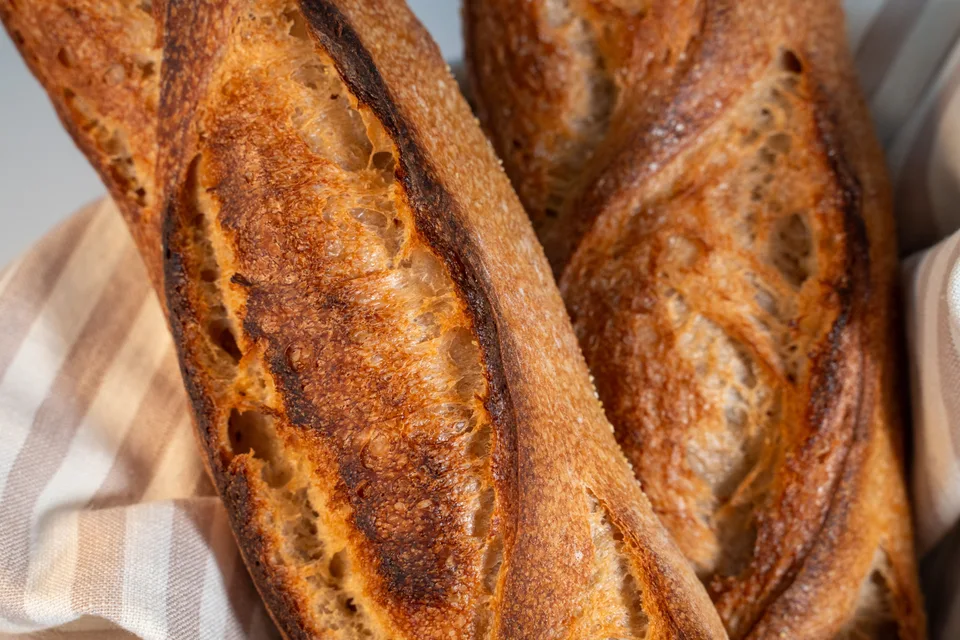 BookNoFees: Beispielfoto: Goldbraune Baguettes auf einem karierten Tischtuch