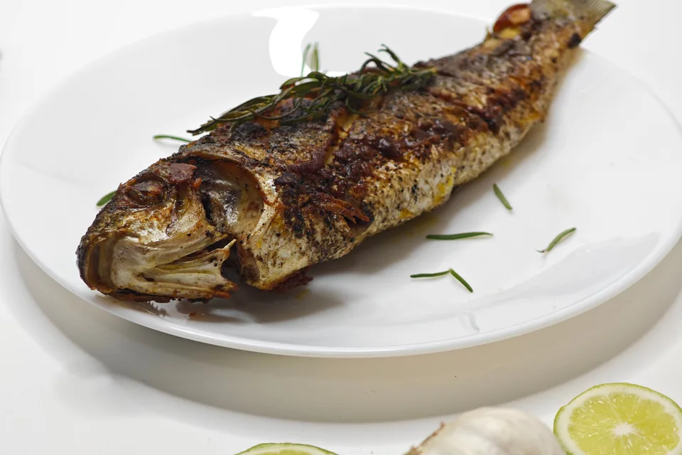 BookNoFees: Beispielfoto: Ganzer gegrillter Fisch auf einem weißen Teller