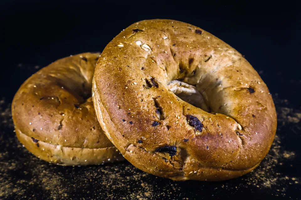 BookNoFees: Beispielfoto: Zwei goldbraune Bagels auf dunklem Hintergrund